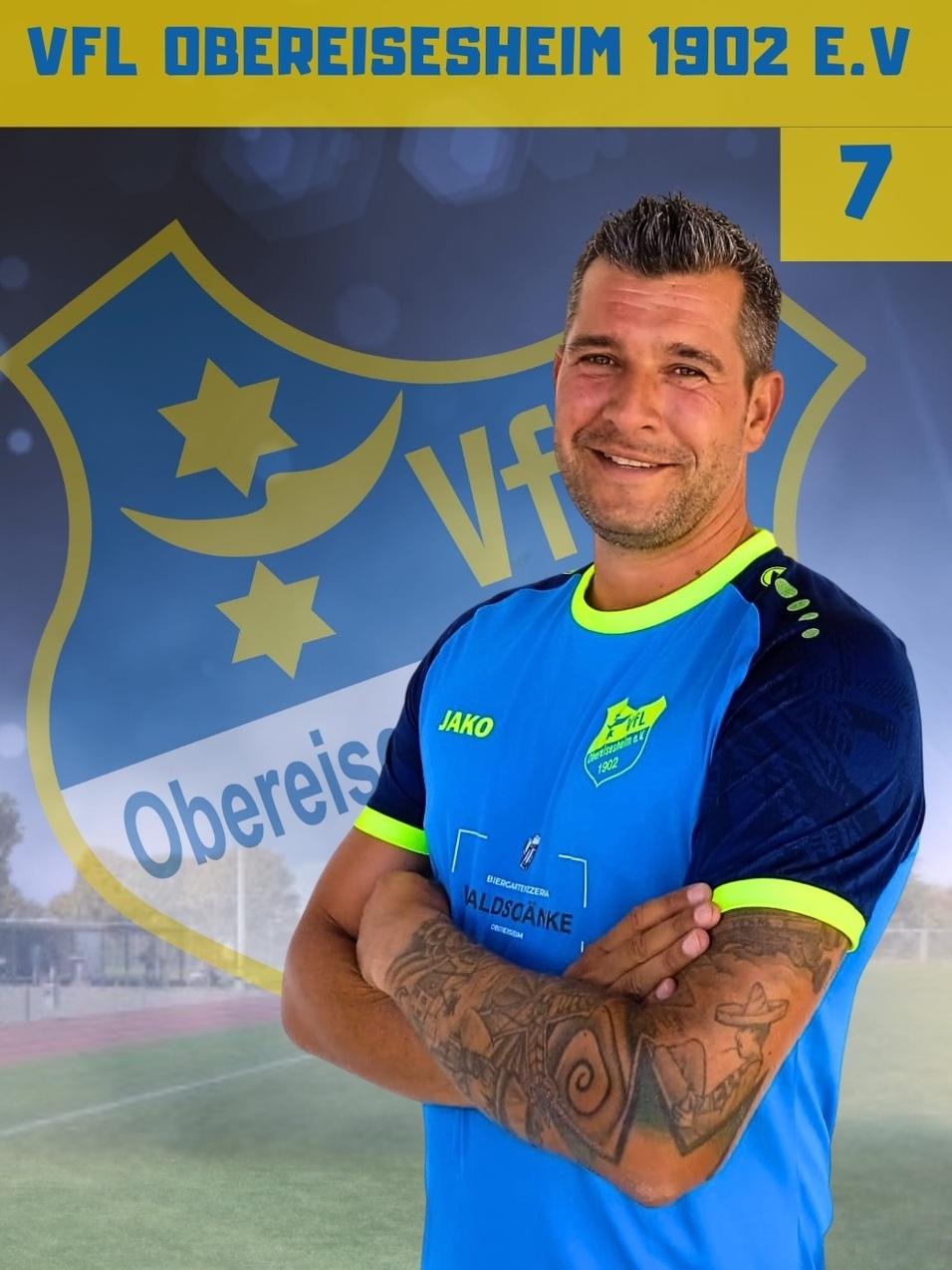 Portrait eines Fu&szlig;ballspielers im blauen Trikot mit dem Namen &bdquo;Patrick Kalhofer&ldquo; und Vereinslogo im Hintergrund.