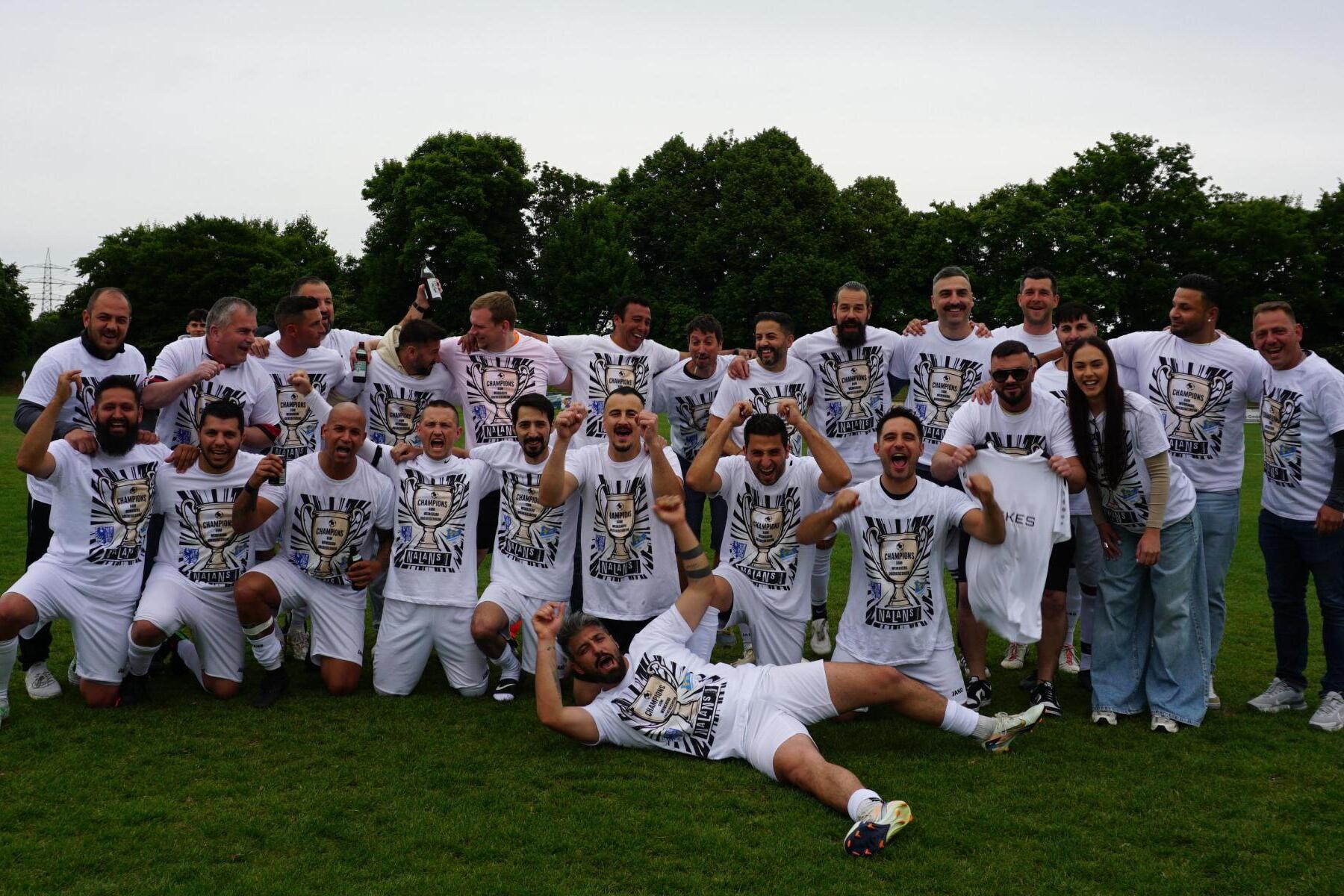 Gruppe von Fu&szlig;ballspielern in wei&szlig;en T-Shirts, posierend auf einem gr&uuml;nen Rasenfeld, feiern zusammen.