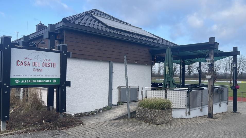 Eingang zum Restaurant Casa del Gusto mit Terrasse und begr&uuml;ntem Bereich, umgeben von einer klaren Landschaft.